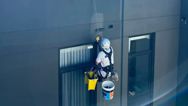 rope access painter working on strata high rise building 