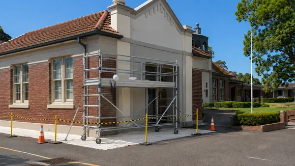 ongoing painting of sydney school exterior using scaffolding